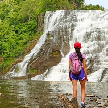 Ung kvinde beundrer Ithaca Falls - New York State