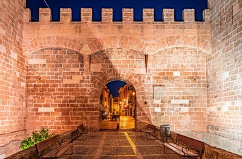 Alcudia, Mallorca, Spanien - kik gennem bymuren ved aftentide