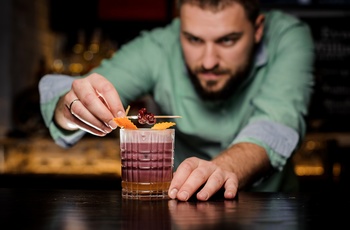 Bartender tilbereder cocktailen New York Sour