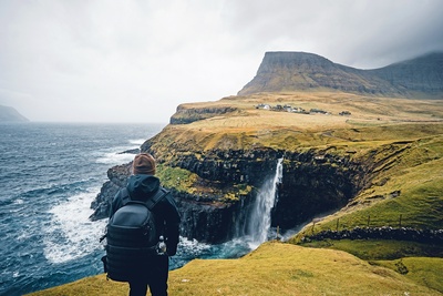 Hiker ser på Mulafossur vandfaldet, Gasadalur på Færøerne