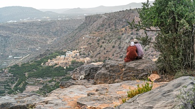 Lokale kigger ud over dal med en landsby i Oman
