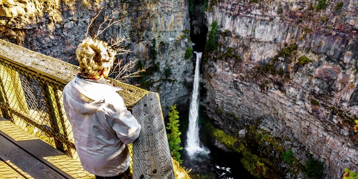 Kvinde ved vandfaldet Spahats Falls i Wells Gray Provincial Park, British Columbia i Canada