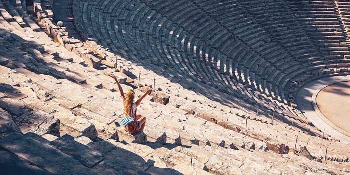Ung kvinde midt i det antikke teater i Epidaurus på Peloponnes-halvøen