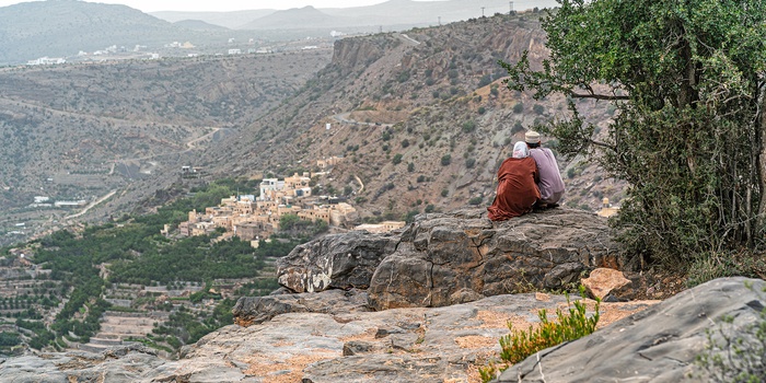 Lokale kigger ud over dal med en landsby i Oman