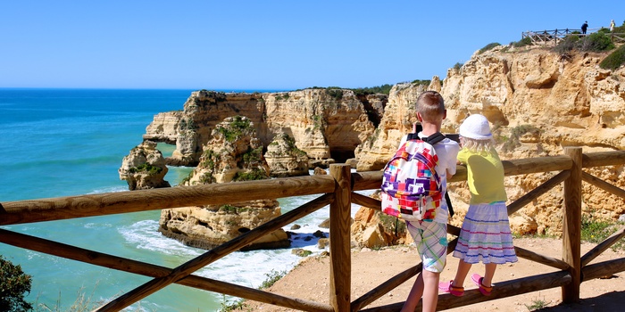 2 børn kigger ned på strand i Algarve, Portugal