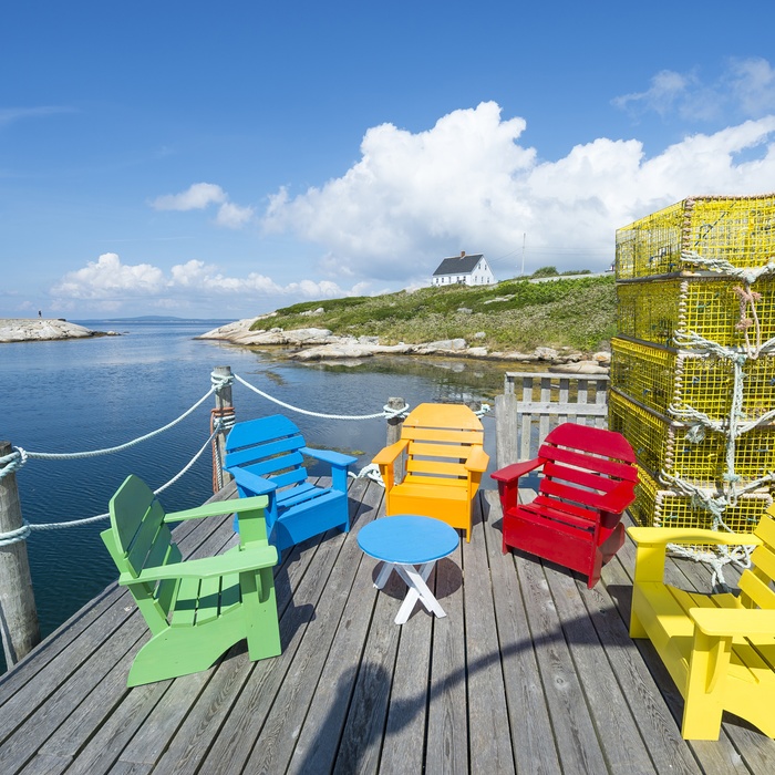 Farverige stole på terrasse i kystbyen Peggy´s Cove havn, Nova Scotia i Canada