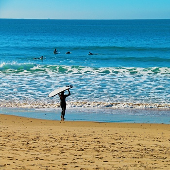 Surfer på stranden og på vej ud til surfere - Andalusien