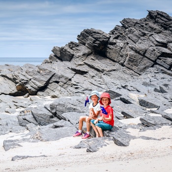 Børn på klippefyldt strand i Australien 