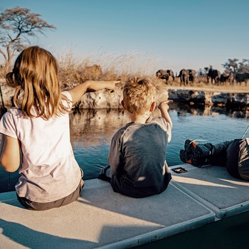 Børn ser elefanter ved floden Kwando River Caprivi i Namibia