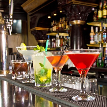 5 forskellige cocktails på bardesk i hyggelig bar