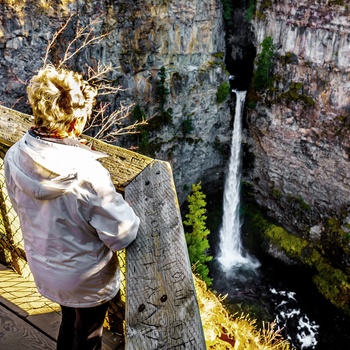 Kvinde ved vandfaldet Spahats Falls i Wells Gray Provincial Park, British Columbia i Canada
