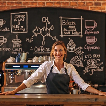 Stolt ejer af cafe bag desken