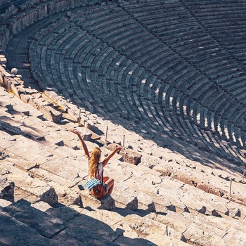 Ung kvinde midt i det antikke teater i Epidaurus på Peloponnes-halvøen