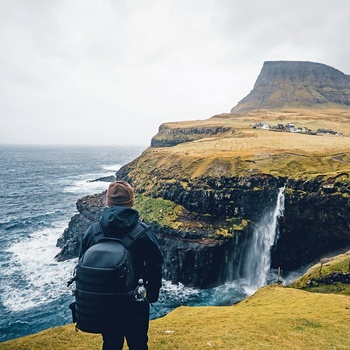 Hiker ser på Mulafossur vandfaldet, Gasadalur på Færøerne