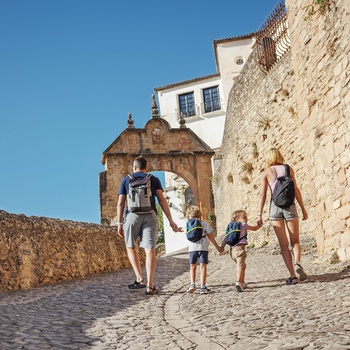 Familie på tur gennem gammel bydel i Sydspanien