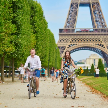 Ungt par cykler nær Eiffeltårnet i Paris, Frankrig