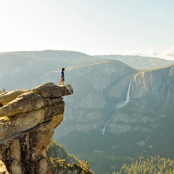 Hiker ved Glacier Point med udsigt til Yosemite Valley og Falls, Californien