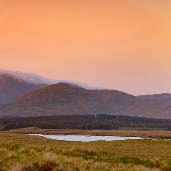 Orangerødt aftenlys over landskabet i Connemara, Vestirland