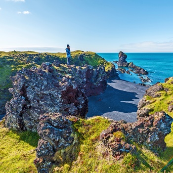 Hiker ser ned på Djúpalónssandur sorte strand på Snæfellsnes halvøen, Island