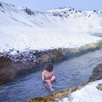 Hop i den varme flod i dalen Reykjadalur nær Reykjavik, Island