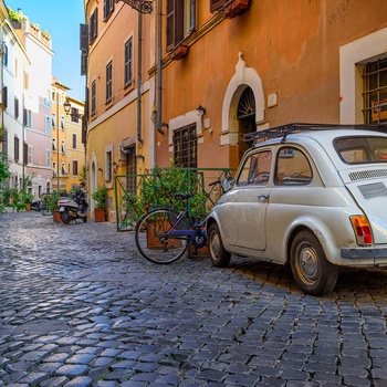Lille Fiat 500 parkeret i gammel gade i Trastevere i Rom, Italien