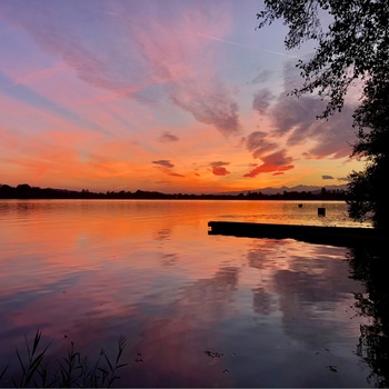 Smukke Lago di Monate i orange toner ved solnedgang