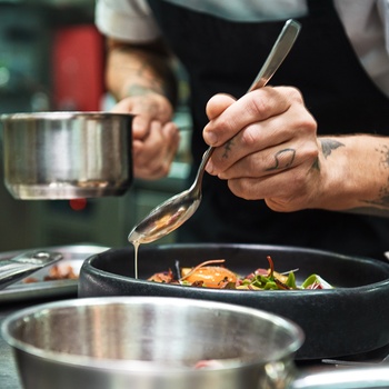 Kok tilbereder mad i køkken