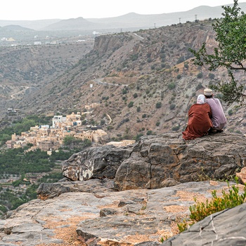 Lokale kigger ud over dal med en landsby i Oman