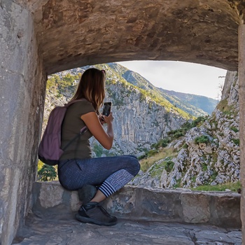 Kvindelig turist tager billeder i Lovćen National Park i Montenegro