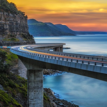 Solnedgang over broen Sea Cliff Bridge, New South Wales