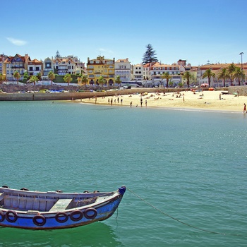 Fiskebåd med kystbyen Cascais i baggrunden - Portugal