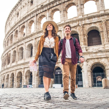 Ungt par foran Colosseum i Rom, Italien