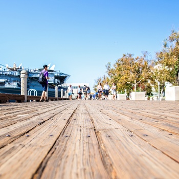 Promenade forbi USS Midway i San Diego, Californien i USA