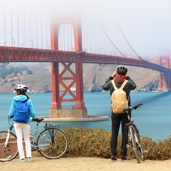 Par på cykel fotograferer Golden Gate, San Francisco i USA