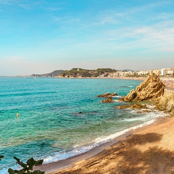 Lækker strand med feriebyen Lloret de Mar i baggrunden - Spanien 