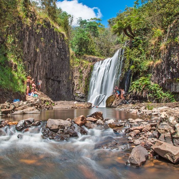Vandfald med turister der bader, Tasmanien