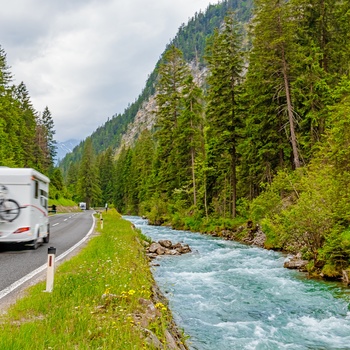 Autocamper på vej gennem skovklædte bjerge i Tyskland