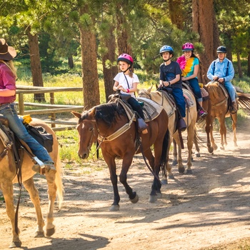 Familie på ridetur fra ranch i Rocky Mountains - USA