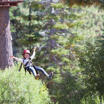 Barn prøver zipline i en skov