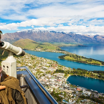 Ung kvinde kigger ned på Wakatipusøen ved Queenstown, Sydøen