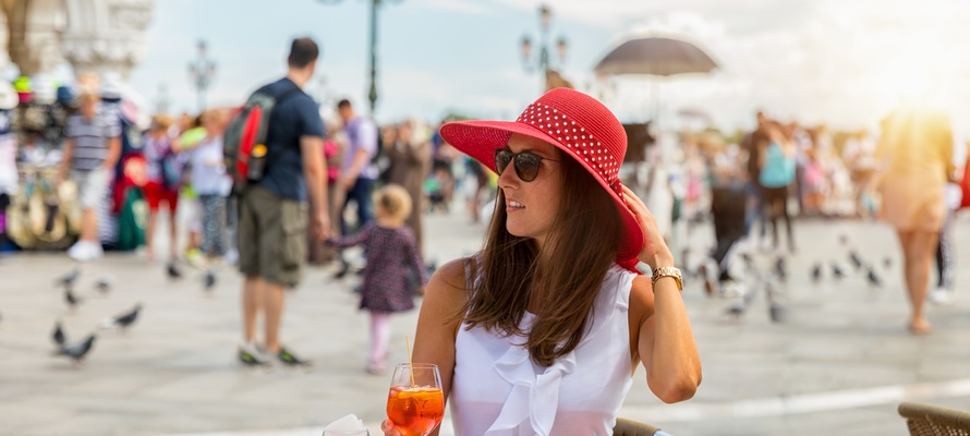 Ung kvinde ved cafebord på Markuspladsen i Venedig