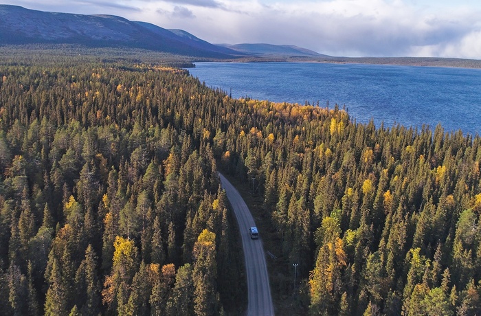 Autocamper gennem skov ved Pallastunturit søen i Lapland - det nordlige Finland