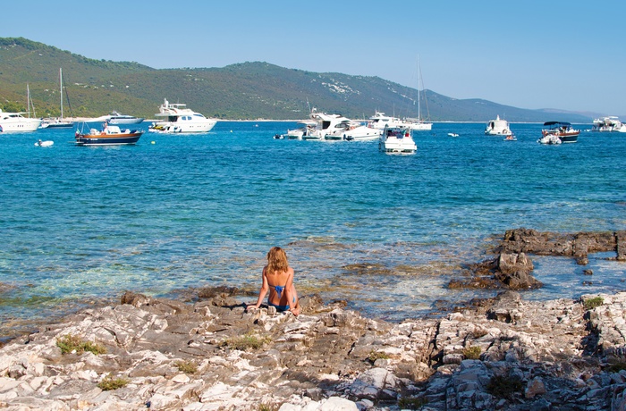 Kvinde i vandkanten på øen Dugi Otok i den kroatiske skærgård, Dalmatien i Kroatien