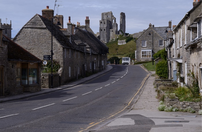 Slotsruinen i Corfe Castle set fra landsbyen, Dorset i Sydengland
