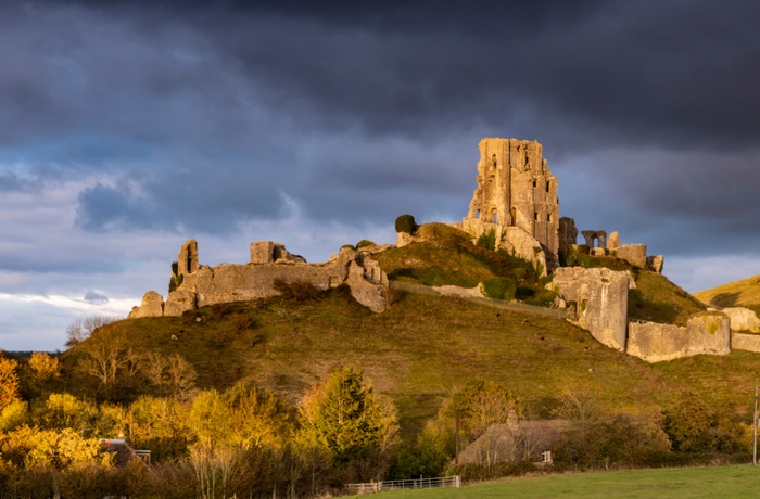 Den smukke slotsruin Corfe Castle i solnedgang, Dorset i Sydengland