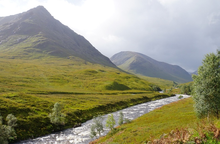 Floden River Coe skærer sig igennem det grønne landskab i Glencoe, Skotland