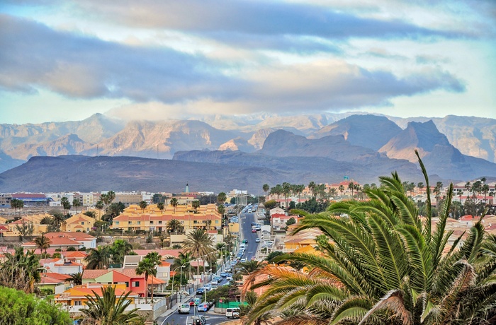 Vej gennem Maspalomas og udsigt til bjergene i baggrunden, Gran Canaria i Spanien