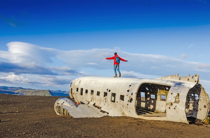 DC-3 flyvraget på en solskinsdag på Sólheimasandur strand, Island