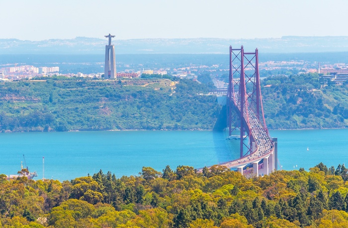 d. 25 april broen over Tajo floden med statuen i baggrunden, Lissabon