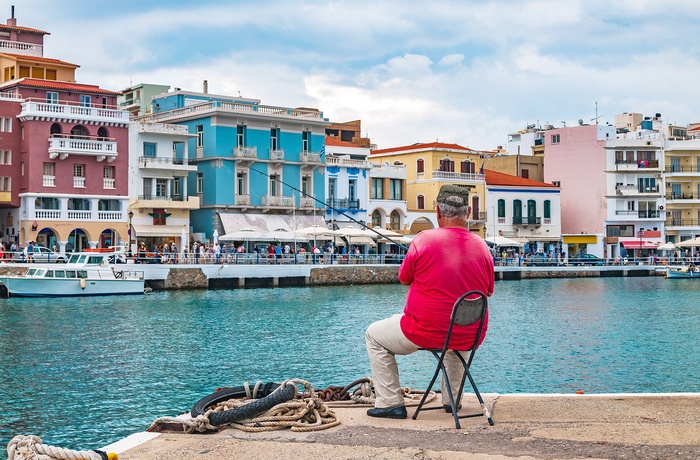 Lokal mand sidder og fisker i havnen i Agios Nikolaos på Kreta